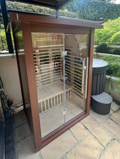 Outdoor shower enclosure with glass door on a patio