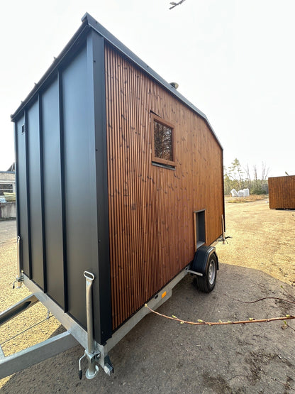 The Nomad mobile sauna interior with panoramic glass and forest view