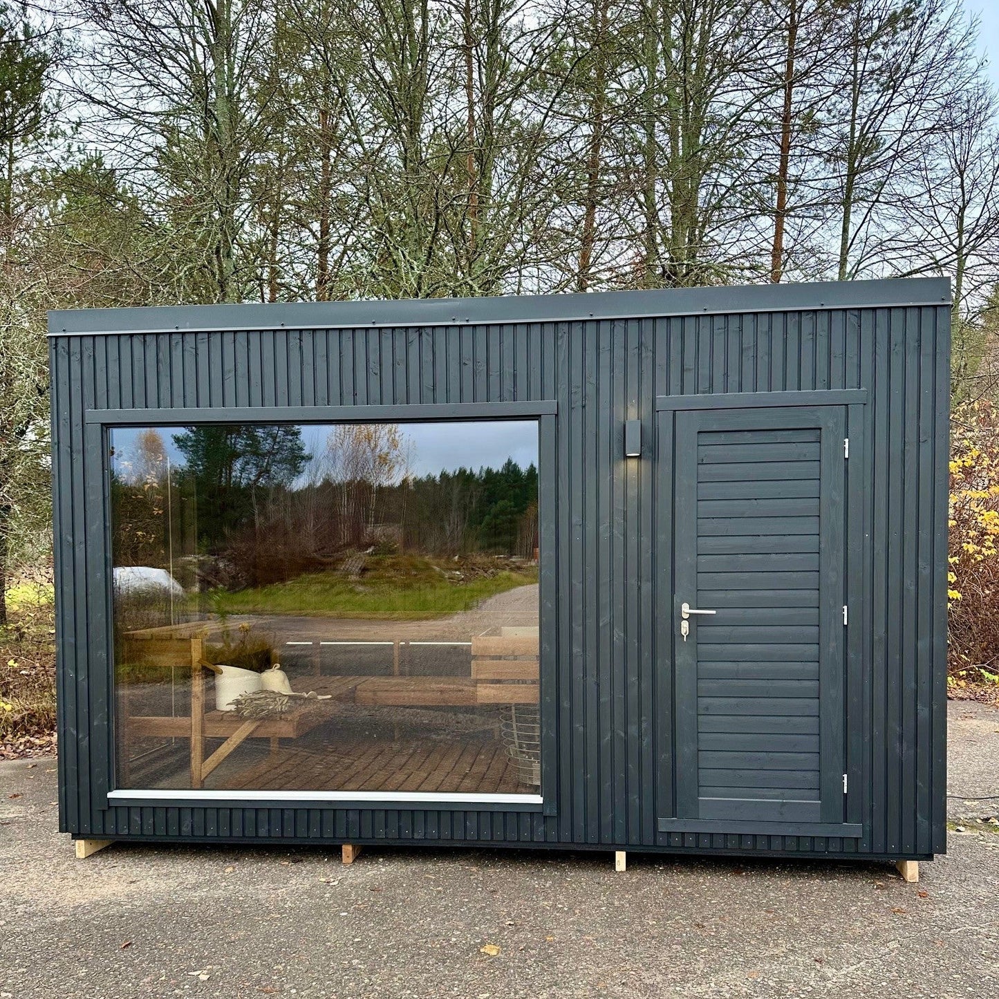 Modular building with glass wall and door in a forest setting