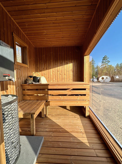 Thermo-wood interior of the Nomad mobile sauna with a panoramic window