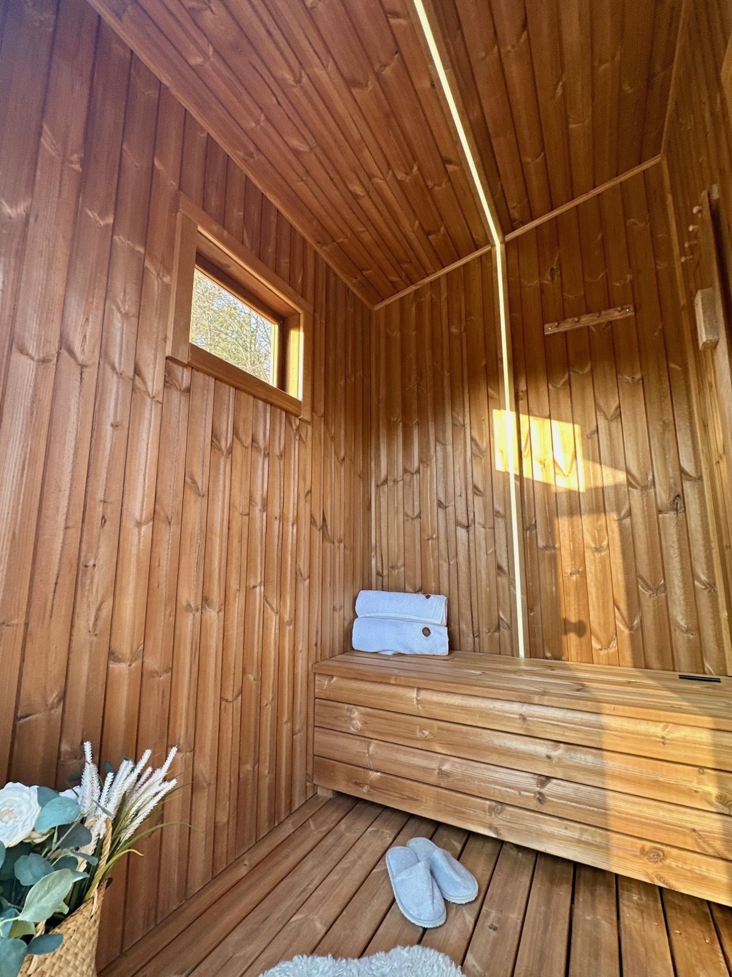 The Nomad mobile sauna changing room with a bench and tinted window