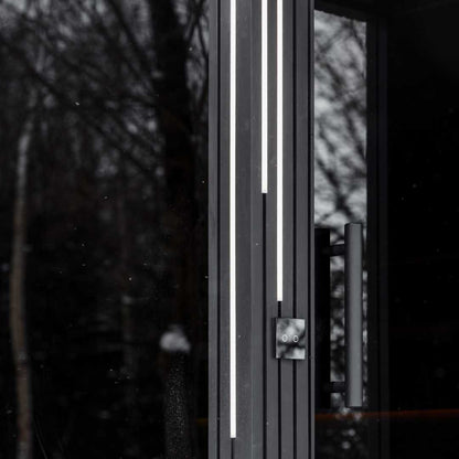 EBON outdoor sauna with shower, exterior at dusk with LED lighting lit