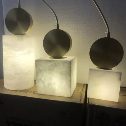 Three stone-effect pendant lights glowing warm white, square and round shapes