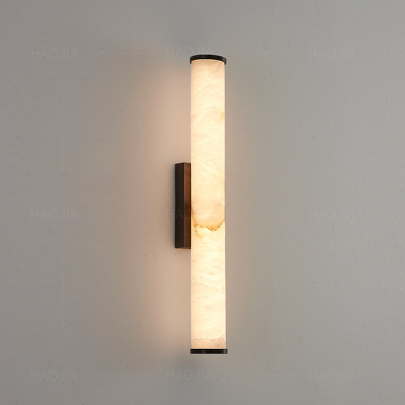 Vertical linear wall sconce with warm stone shade detail