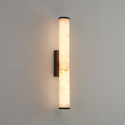 Vertical linear wall sconce with warm stone shade detail