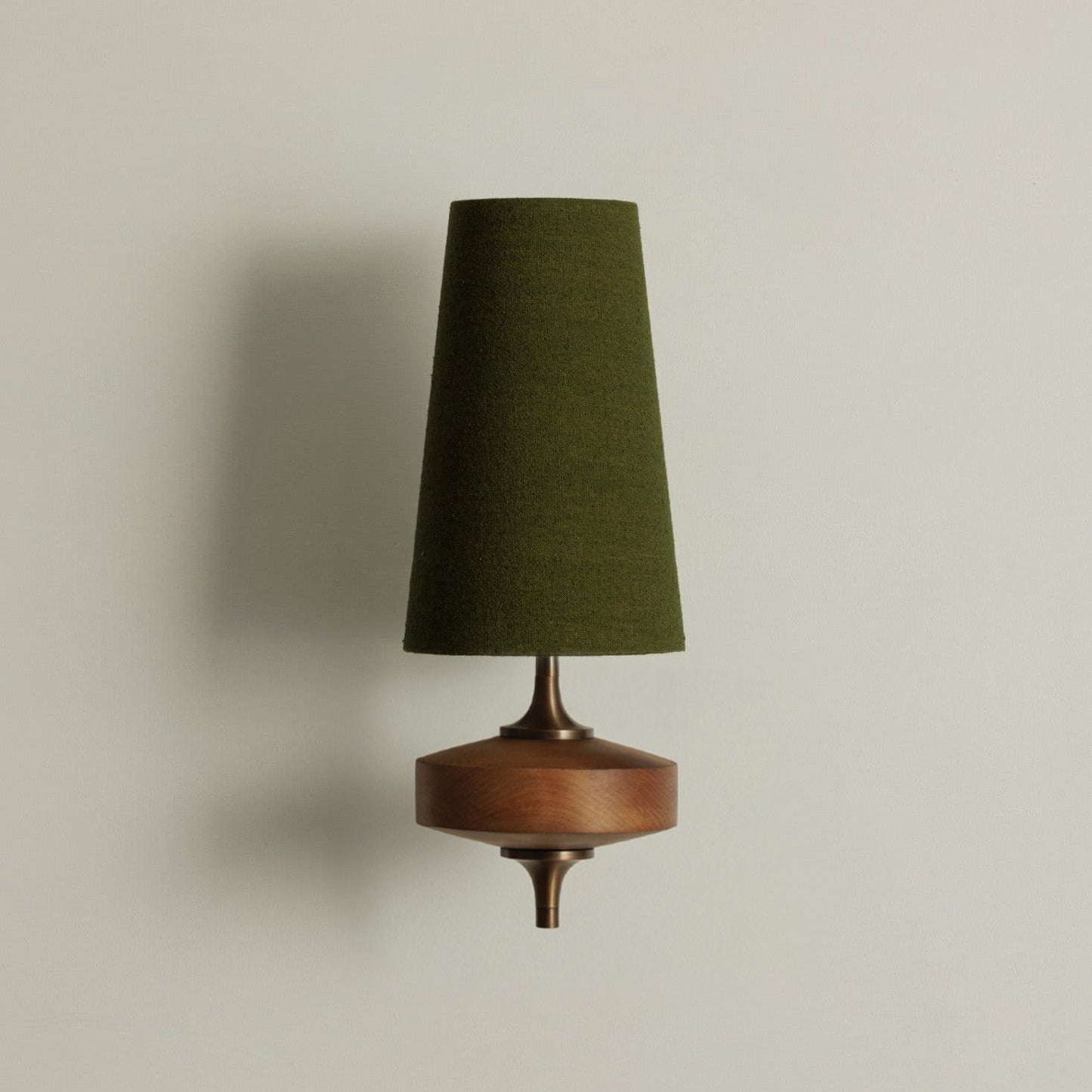 Single walnut and brass wall sconce with green linen shade