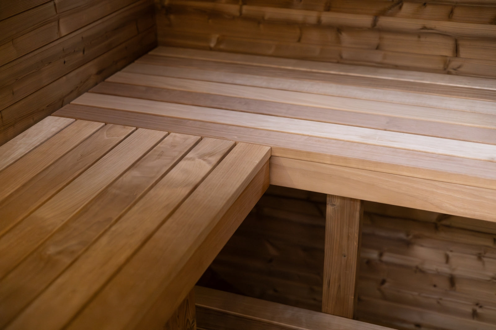 Quadra X sauna interior detail showing bench, floor and glazed front from inside