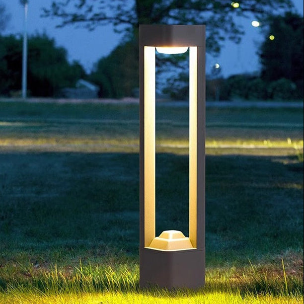 Aluminium garden bollard light lit on a garden pathway at dusk