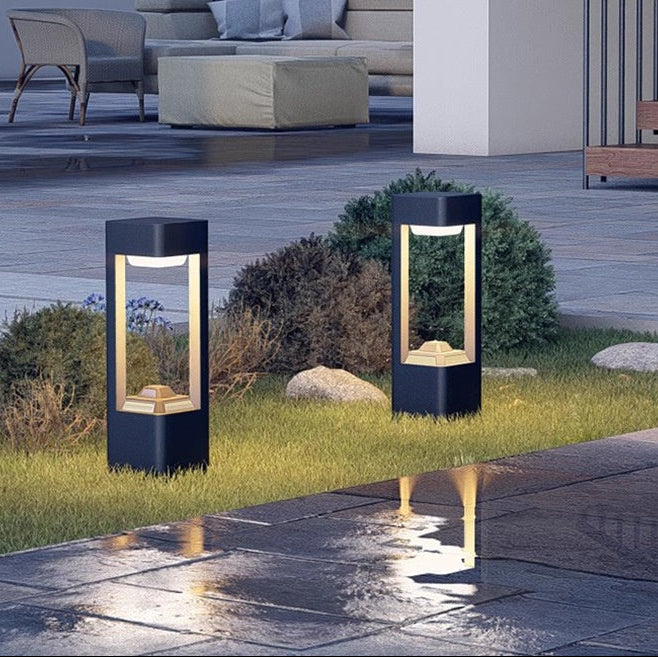Garden bollard light installed in a planted border outside a villa
