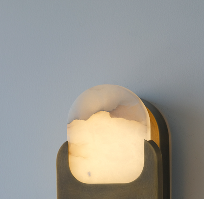 Copper oval alabaster sconce lighting a corridor wall