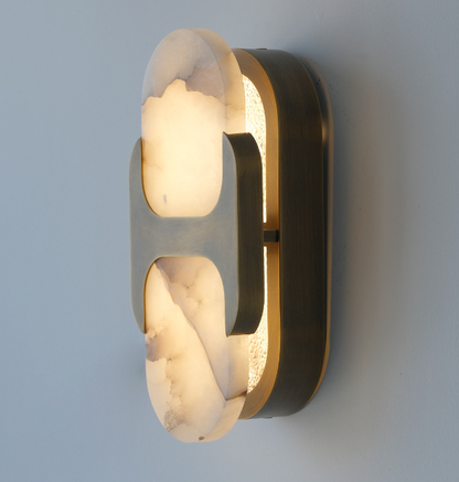 Natural alabaster oval wall light with a warm glow through the translucent stone
