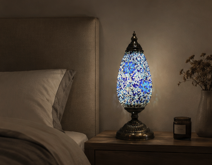 Serena Turkish mosaic table lamp lit on a wooden bedside table beside a bed in a warm bedroom