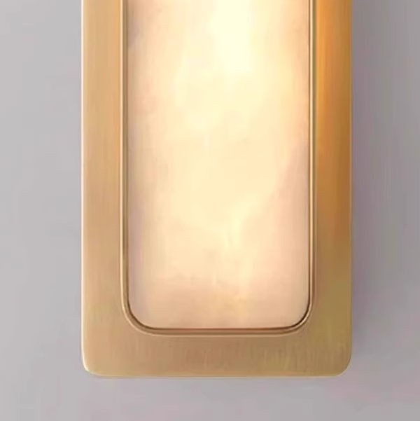 Copper and marble wall light mounted in a stairwell of a hotel interior