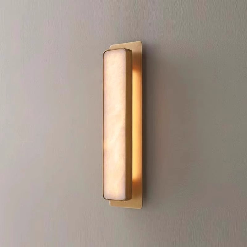 Cylindrical marble wall sconce detail with 2700K warm white light through the stone