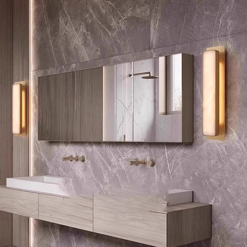 Natural marble cylindrical wall light with a copper frame, showing the stone veining