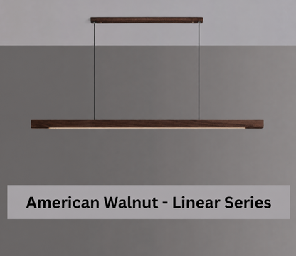 A linear pendant light in a dark American Walnut finish, suspended by two black cables from a matching top bar, shown against a split gray and white background with a text overlay at the bottom reading 'American Walnut - Linear Series'.